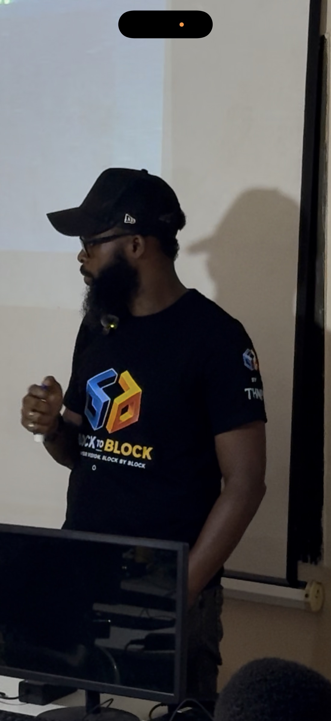 Abdul Malik Jalloh speaking to young learners at the front of the computer classroom